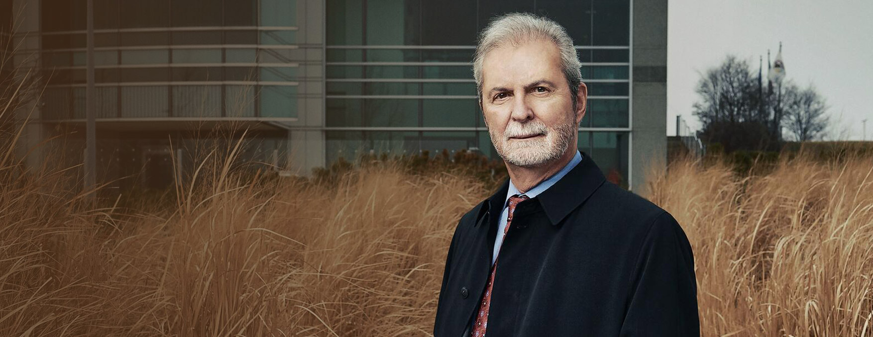 John P. Calamos, Sr. standing in front of building